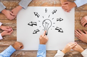 close up of business team pointing to bulb doodle