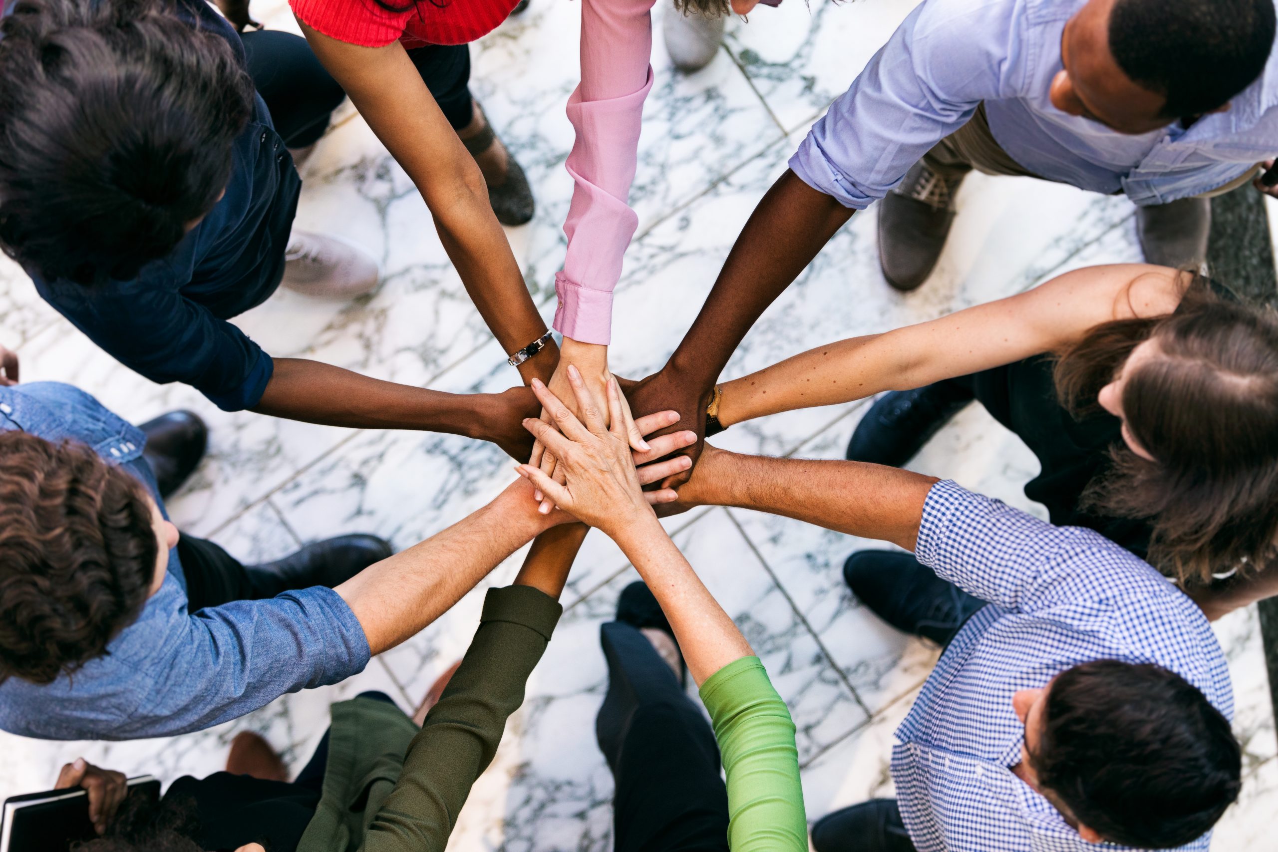 Workspace: Team Of Diverse Workers Put Hands Together Workspace: Team Of Diverse Workers Put Hands Together